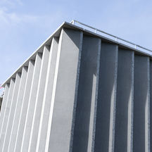 exterior of a modern stone building against a blue sky