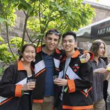 A group of people smiling and holding beers