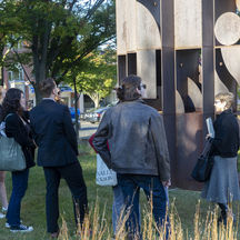 A light-skinned woman leads a tour of the Museum's outdoor art