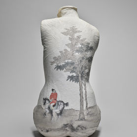 A mold of a human woman's torso; the back is painted with a tree and a man in a red coat on a horse