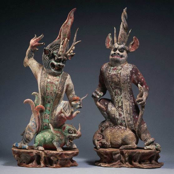 Set of floral painted horned figures each on a separate base, standing over small demon-animals.