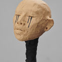Clay sculpture of a head with black tears streaming down from both eyes.