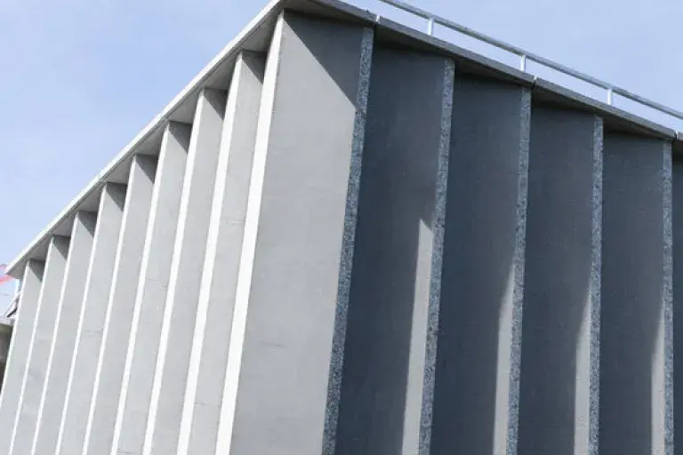 Exterior of a modern stone building against a blue sky.