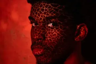 A face with a red background and a pattern over the face.