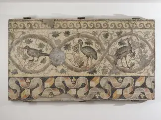 Ancient mosaic depicting birds surrounded by vegetal and geometric motifs.